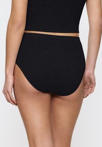 Zwarte high-waisted slips met een gladde, geribde structuur en een elastische tailleband. Heeft een klassieke snit voor volledige dekking aan de achterkant.