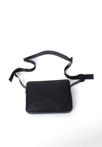 Borsa a tracolla nera in pelle con superficie testurizzata, forma rettangolare, tracolla regolabile e design minimalista.