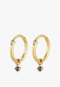 Pendientes de aro de oro con un acabado suave, que presentan un pequeño acento de gema azul colgando de cada aro. Diseño sencillo y redondo.