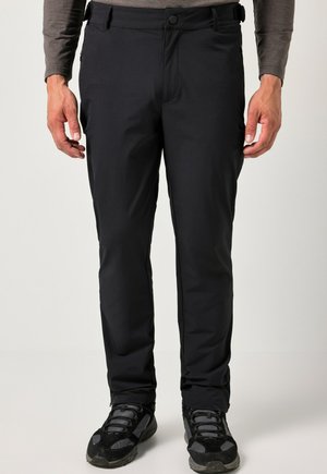 Zwarte outdoor broek met een gladde, lichte textuur, voorzien van een rits- en knoopsluiting, en gedragen met zwarte wandelschoenen.