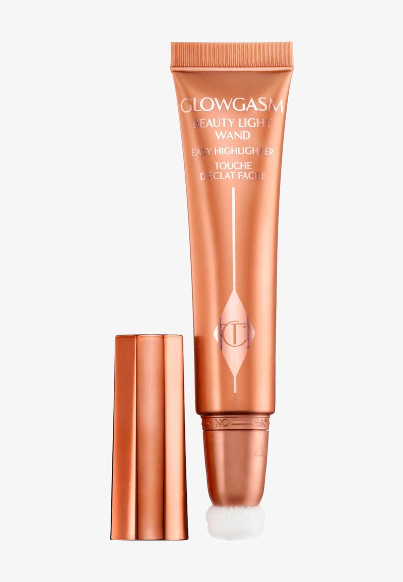 Tube d'illuminateur Glowgasm Beauty Light Wand ton cuivre avec applicateur doux fixé et bouchon assorti à côté sur fond blanc.