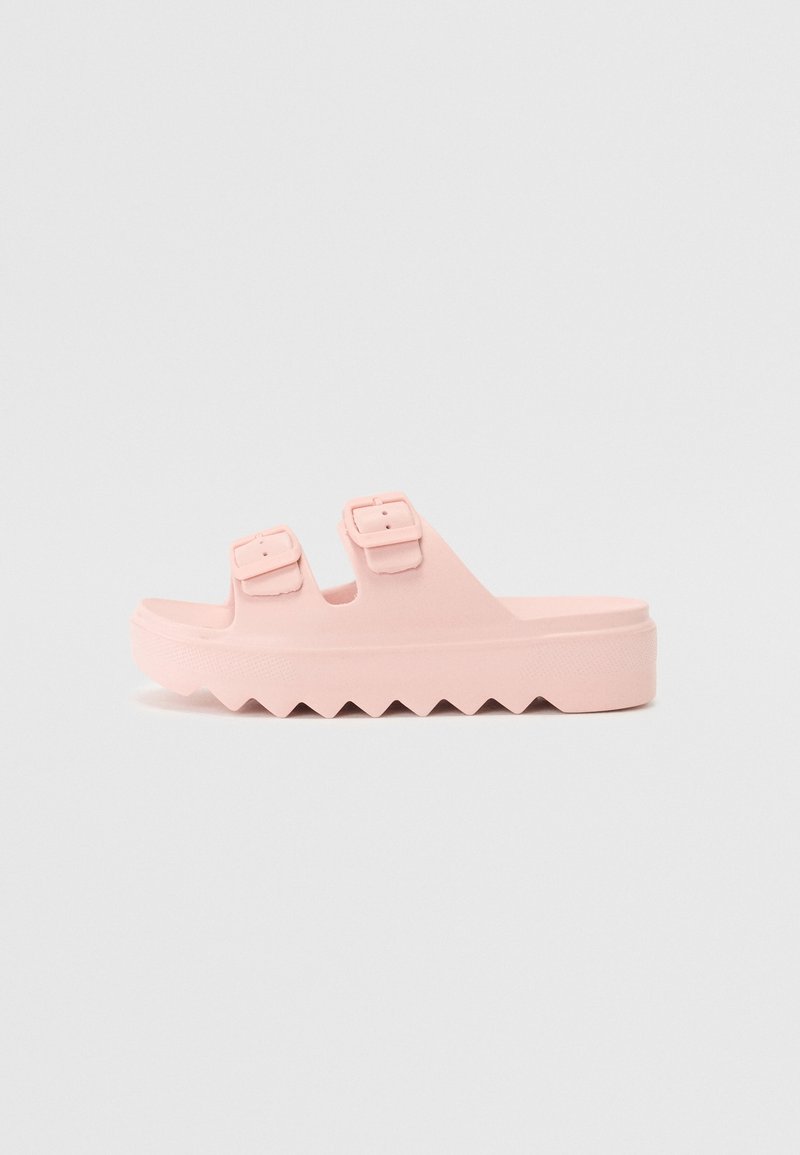 Sandale à plateforme rose avec deux brides réglables à boucle et une semelle à motif en zigzag.