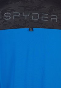Blå træningsskjorte med en sort tekstureret overdel og "SPYDER" logo. Glat stof med farveblokeret design og en løkke til ophængning.
