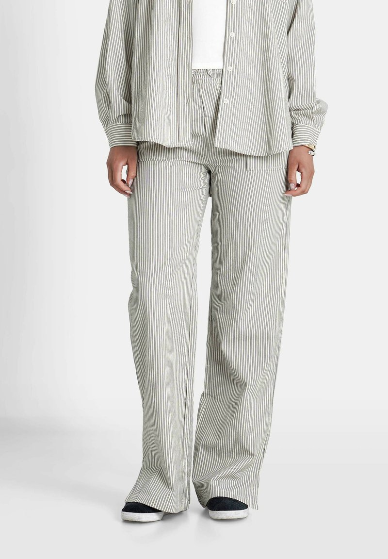 Gestreepte lichtgroene en witte lange mouwen shirt gecombineerd met bijpassende wijde broek, vervaardigd uit een gestructureerde stof en met een ontspannen pasvorm.