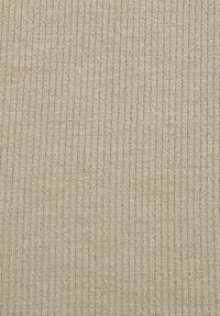 Tessuto a coste beige con una morbida texture, caratterizzato da sottili righe verticali e un motivo di maglia uniforme, adatto per vari capi di abbigliamento.