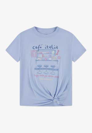 Lys blå bomulls-T-skjorte med knyttet kant, med en illustrasjon av en kafé og tekst i rosa og mørk blå. Korte ermer og rund hals.