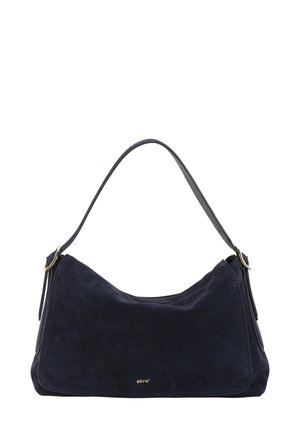 Navy suede shoulder bag with a curved shape, a single top handle, and a small gold logo on the front. Smooth texture with minimal hardware.