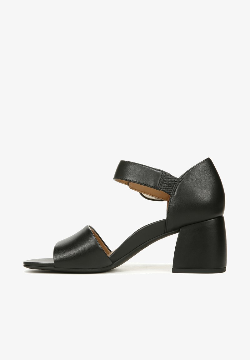 Zwarte leren hak sandaal met een brede voorband, verstelbare enkelband en een chunky blokhak met een gladde afwerking.