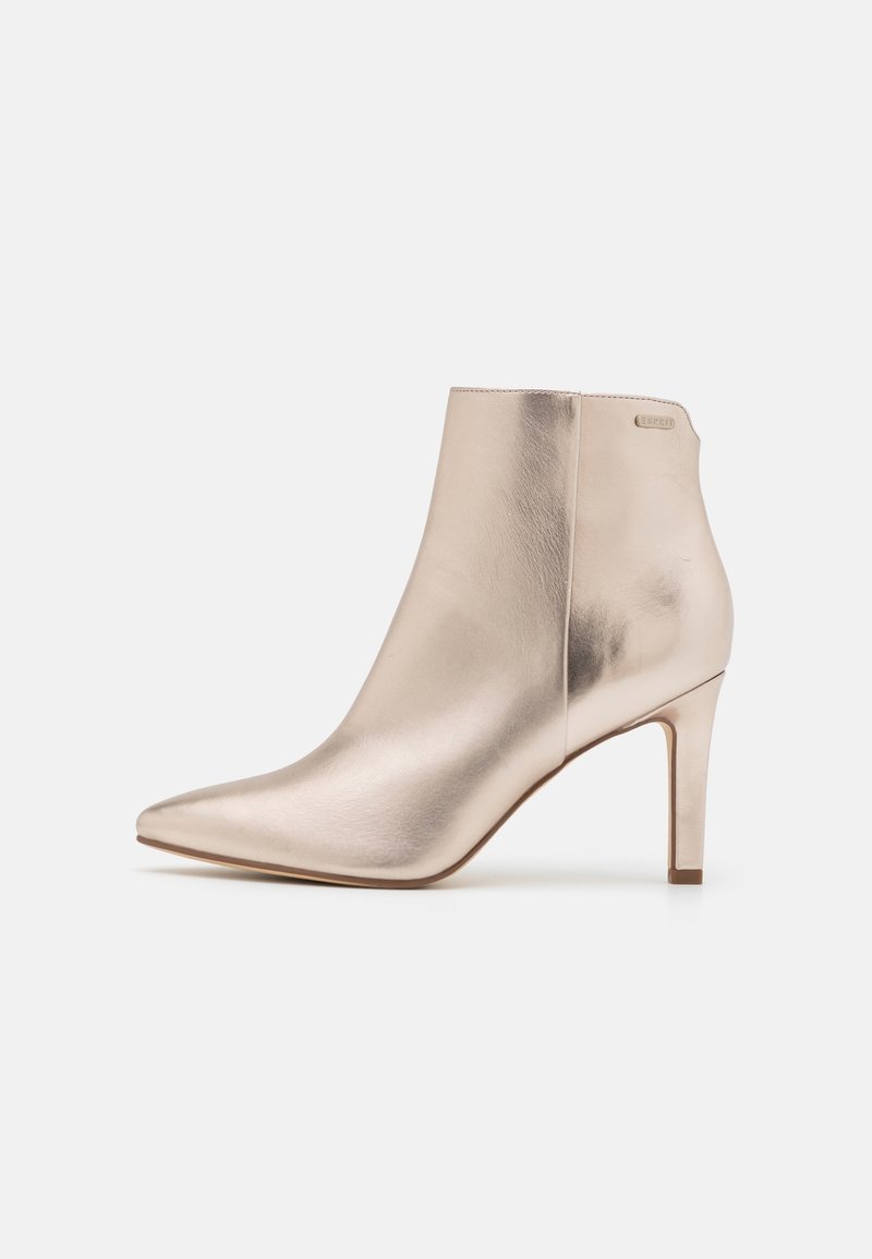 Bottine femme beige métallique à bout pointu et talon haut fin, finition lisse effet cuir.