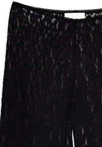 Svarta spetsbyxor med ett strukturerat, öppet vävmönster och en scalloped midja. Det lätta materialet ger en genomskinlig look.