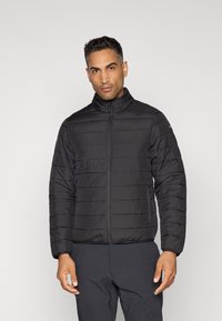 Veste matelassée noire avec col haut, présentant une texture matelassée horizontale, une fermeture éclair à l'avant et deux poches latérales. Design ajusté.