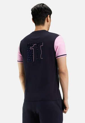 T-shirt à manches courtes bleu marine et rose avec un graphique « 11 » en grand au dos, présentant des textures de tissu contrastantes et une coupe slim.