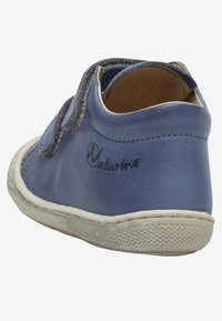 Blauer Lederschuh mit einem strukturierten grauen Riemen, rundem Logo und weißer Gummisohle. Hat eine abgerundete Zehenform und eine glatte Oberfläche.