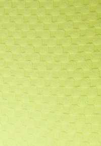 Tecido texturizado em verde lima vibrante, apresentando um padrão trançado com quadrados elevados alternados e seções planas, criando profundidade visual.
