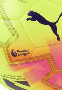 Pallone da calcio giallo e rosa con pannelli esagonali, superficie testurizzata, logo Puma nero e marchio "Premier League" con emblema del leone.