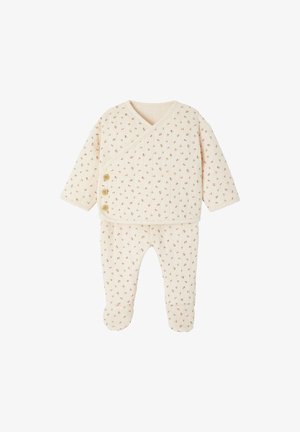 Cotton baby outfit in cream with a wrap design, dotted with small red flowers. Features two wooden buttons on the front and footed pants.