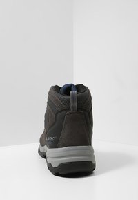 Mid-cut hiking shoe featuring a black and gray suede and mesh upper, padded collar, pull tab, and a rugged rubber outsole.