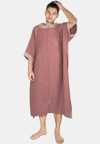 Burgunderfarbener Poncho mit Wabenstruktur, mit Reißverschluss, großen Taschen und Kapuze. Verfügt über einen kontrastierenden Besatz in einer helleren Farbnuance.