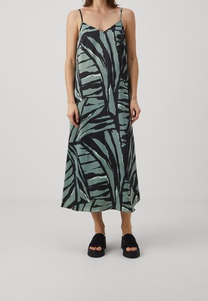 Satin-Maxi-Kleid mit dünnen verstellbaren Trägern, das mit einem grünen und schwarzen Blattmuster, glatter Textur und A-Linie-Silhouette ausgestattet ist.