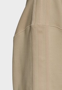 Béžová mikina s texturovaným povrchem, ozdobená panely a třemi vertikálními pruhy na boku. Měkký materiál z bavlněné směsi.