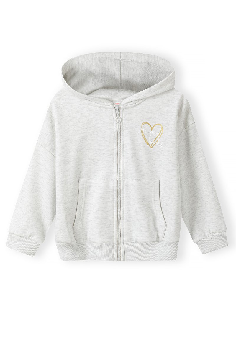 Sudadera con cremallera de color gris claro y textura suave, que presenta un pequeño diseño de corazón dorado en el lado izquierdo del pecho. Incluye bolsillos frontales y capucha.