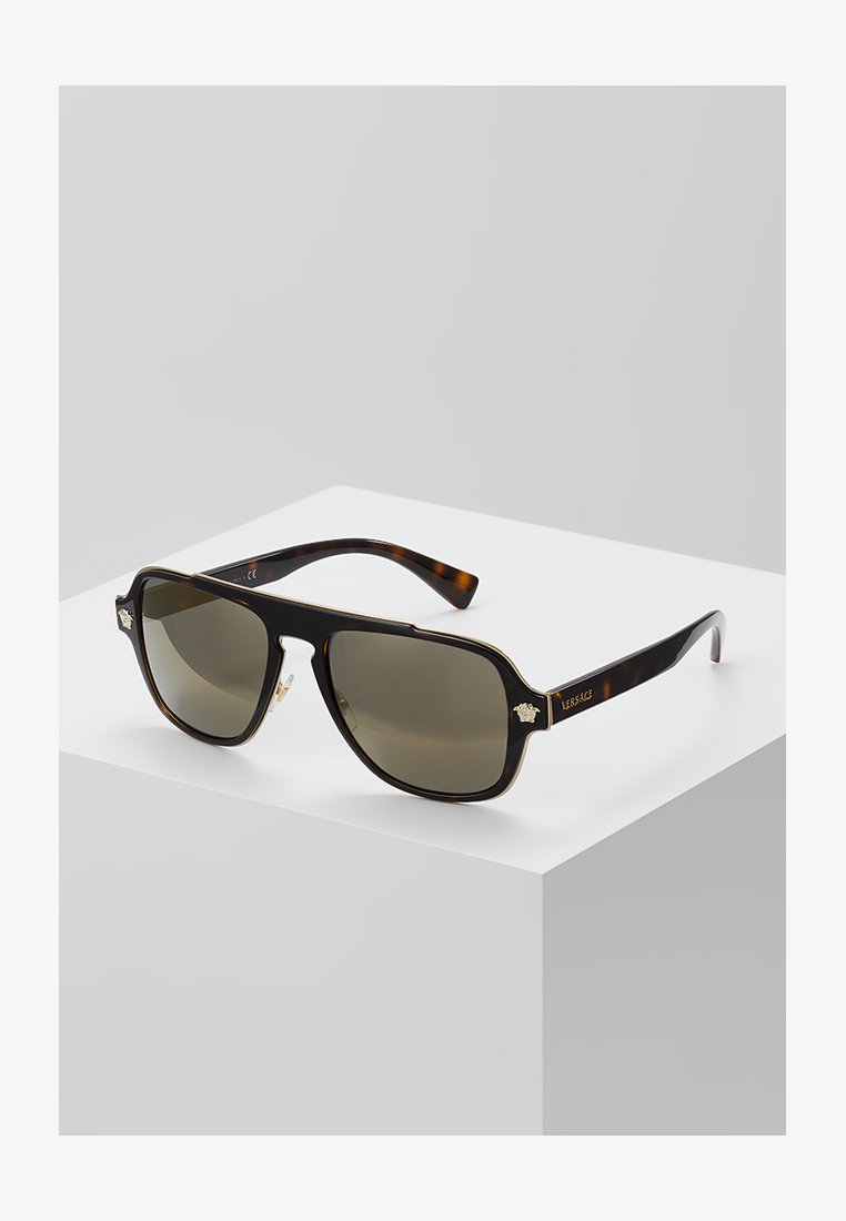 Óculos de sol tortoise castanho com lentes quadradas, tonalidade verde mais escura, detalhes em dourado nas hastes e "VERSACE" gravado na lateral.