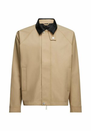 Veste beige à manches longues, col en cuir noir, fermeture avant dissimulée, deux poches et boutons-pression argentés, présentée sur un fond blanc.