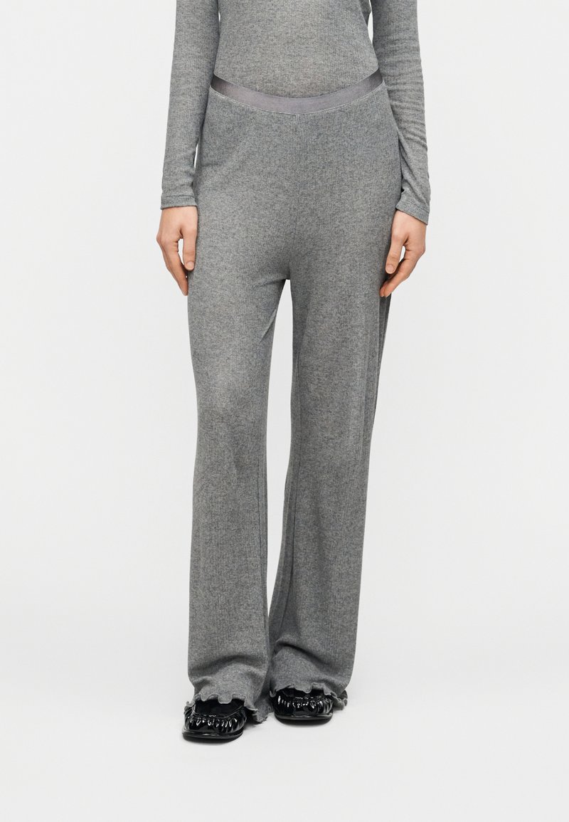 Γκρι πλεκτό παντελόνι με φαρδιά παντελόνα και λείο ζωνάρι στη μέση, με απαλή υφή και διακριτικό ριμπ, σε συνδυασμό με μαύρα παπούτσια με υφή.