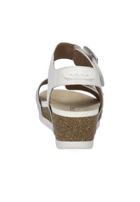 Witte leren sandaal met kurken sleehak, verstelbare band en zachte binnenvoering. Heeft een afgeronde neus en open ontwerp.