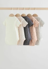 Öt rövid ujjú baba body fa vállfákon lóg, amelyeken apró minták, például pöttyök, szívek és állatminták láthatók semleges színekben.