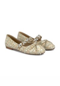Bailarinas con un tejido beige texturizado, decoradas con lentejuelas, un detalle de lazo y una correa decorativa de cuentas en la parte superior.