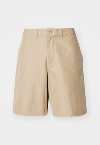 Beige shorts setengah panjang dengan penutup kancing, loop sabuk, saku samping, dan logo bordir kecil di sisi kanan.