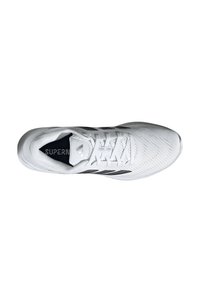 Chaussure de sport blanche avec une tige texturée, des accents noirs sur les côtés et un système de lacets blanc, arborant un logo sur la languette.