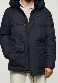 Granatowa kurtka puchowa z kapturem, wyposażona w duże przednie kieszenie, zapięcie na suwak i zatrzaski oraz pikowaną fakturę.