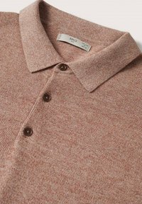 Polo en maille marron clair avec une finition texturée, trois boutons marron et un col classique. L'étiquette indique la taille M et la marque MNG.