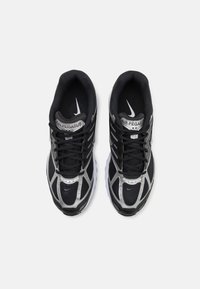 Čierne a strieborné tenisky Nike Air Pegasus s sieťovinovým zvrškom, polstrovaným golierom a gumovou podrážkou. Obsahuje výrazné šnurovanie a logo značky.