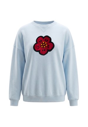 Lyseblå langærmet sweatshirt med ribbet manchetter og kant, med en stor rød blomsterpatch med gule og sorte detaljer på brystet.