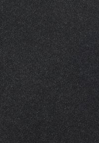 Tessuto di lana nera con una consistenza morbida e pelosa. La superficie appare uniforme e leggermente densa, mostrando un colore consistente senza motivi.