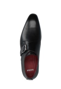 Zwarte leren schoen met een puntige neus, verstelbare zilveren gespsluiting en een bordeauxrood interieur. Smooth tekstuur zonder zichtbare patronen.