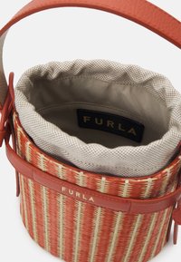 Mała torba na ramię typu bucket z pomarańczowo-beżowym wzorem plecionym, skórzanymi wykończeniami, beżową podszewką oraz metką marki Furla wewnątrz i na zewnątrz.