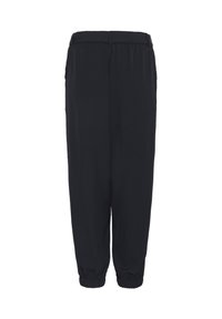 Pantalons noirs fuselés avec une taille élastique et des poignets, présentant une texture lisse et un design simple, adaptés pour le port décontracté.
