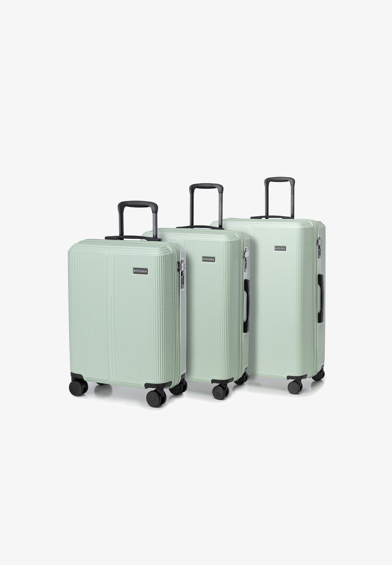 Drie mintgroene harde koffers met een geribbeld ontwerp, zwarte handvatten en wielen. Verschillende maten voor verschillende reisbehoeften.