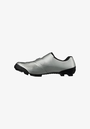 Scarpa da ciclismo argento con suola nera e tacchetti, tomaia traforata per la ventilazione e design elegante e basso.