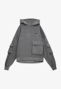 Grå oversized hoodie med frampocket och fickor på ärmarna samt en liten svart broderad logotyp på bröstet.