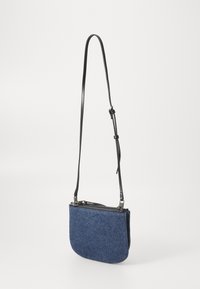 Borsa a tracolla in denim blu scuro con fondo curvo, tracolla nera regolabile e chiusura con zip nella parte superiore. Texture liscia.