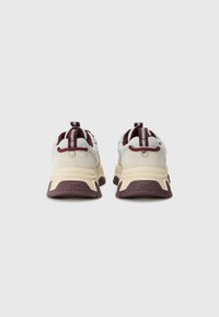 Witte en kastanjebruine sneakers met een gestructureerd bovenwerk, versterkte hiel, opvallende lusjes en dikke, gevoerde zolen met een patroon.