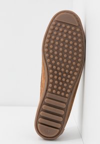Semelle de chaussure en daim marron clair avec une texture antidérapante et un profil arrondi. Présente un profil bas et la taille "37" près du talon.