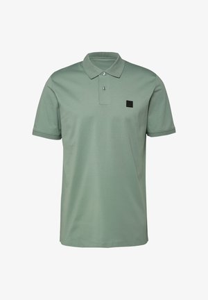 Polo vert sauge à manches courtes avec deux boutons et un petit patch logo carré noir sur la poitrine gauche.