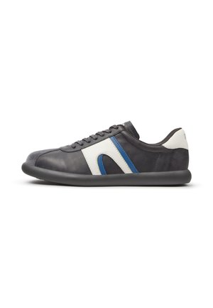 Schwarzer und weißer Sneaker mit blauem Akzent, abgerundeter Sohle und Schnürung vorne, seitlich auf weißem Hintergrund gezeigt.