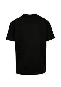 Camiseta de algodón negra con cuello redondo y mangas cortas. La parte posterior es lisa, sin patrones ni adornos. Diseño de corte clásico.
